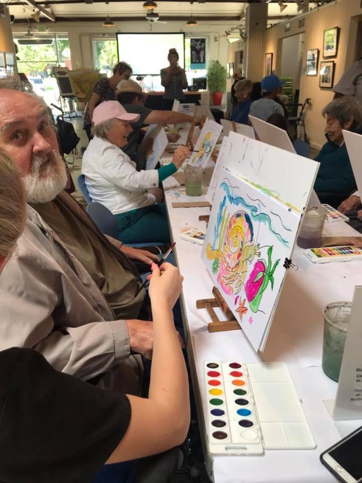 People enjoying a painting workshop, focusing on watercolor techniques.