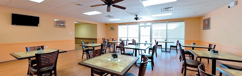 Interior of a restaurant with tables and chairs arranged neatly.