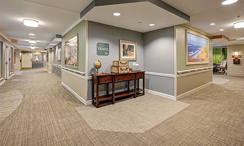 A tastefully decorated hallway featuring a wooden side table adorned with a globe and artwork on the walls.