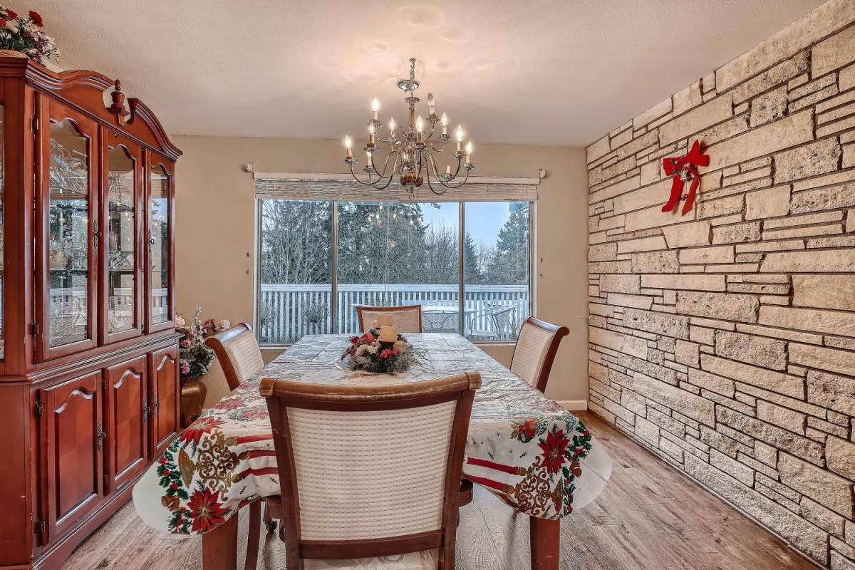 A cozy dining room with holiday decorations and a view of the snowy outdoors.