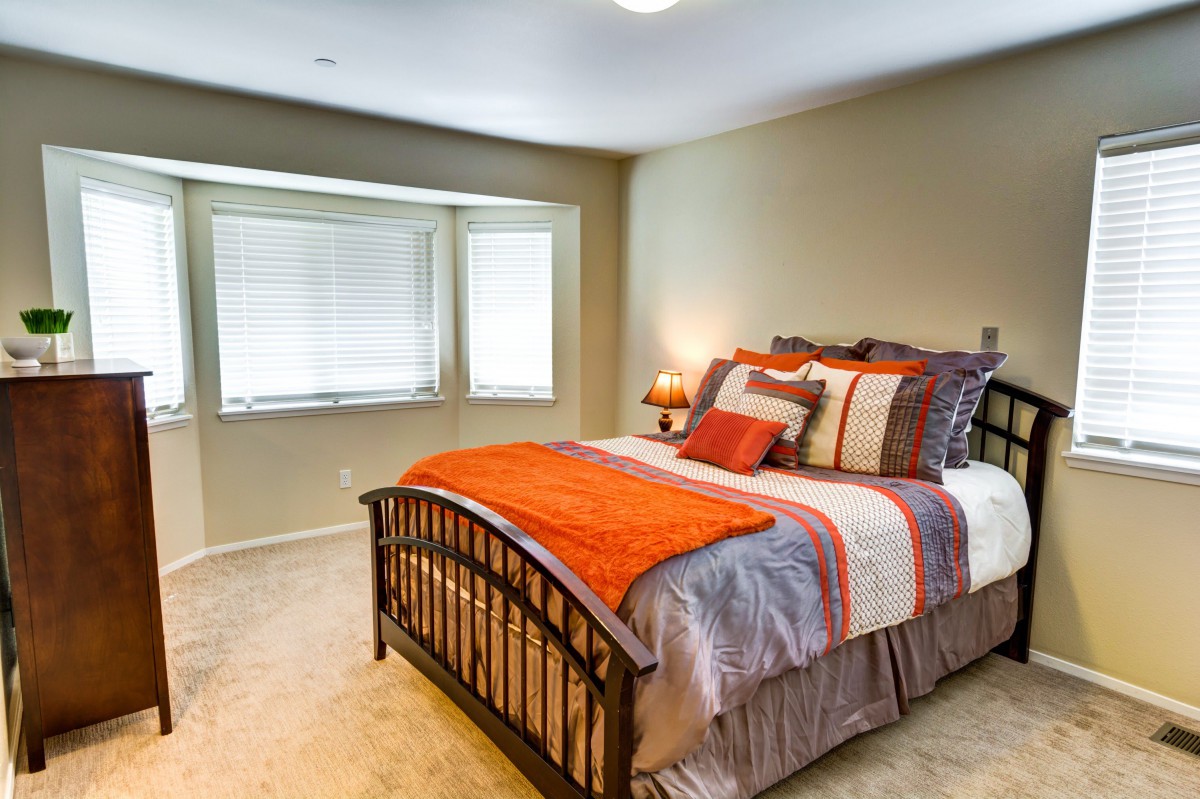 A cozy bedroom with a neatly arranged bed and vibrant decor.