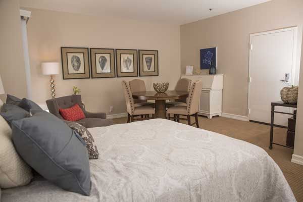 A well-decorated bedroom with a cozy seating area and stylish artwork.