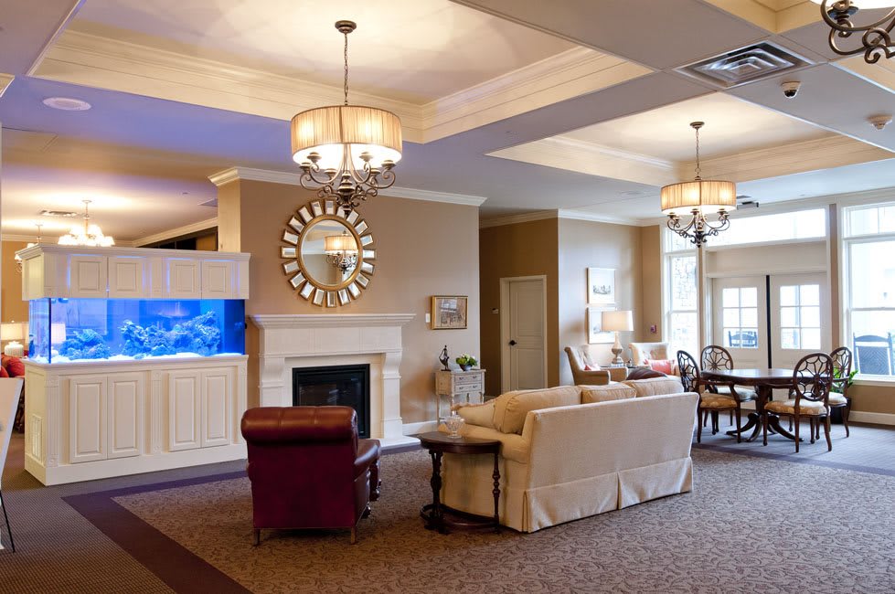 A cozy living room with elegant chandeliers, a comfortable sofa, and a fireplace.