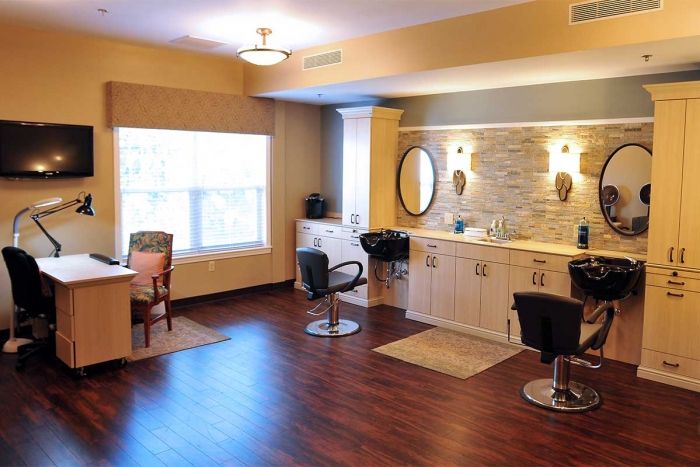A well-lit salon interior featuring stylish chairs, mirrors, and wooden flooring.