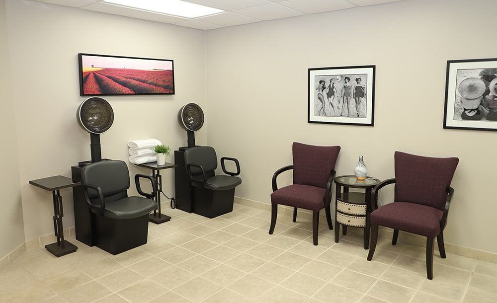 A salon waiting area with chairs and hair dryers.