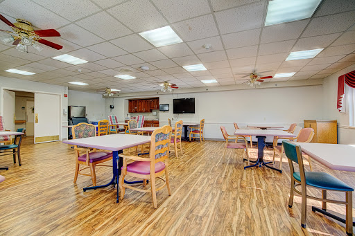 A spacious and well-lit dining area featuring several tables and chairs, designed for social gatherings.