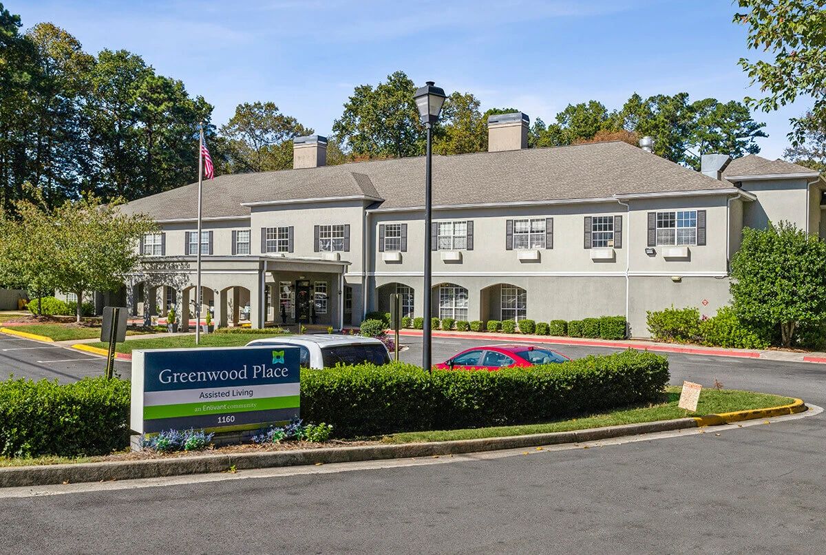 An exterior view of a commercial building with a parking area and well-maintained landscaping.