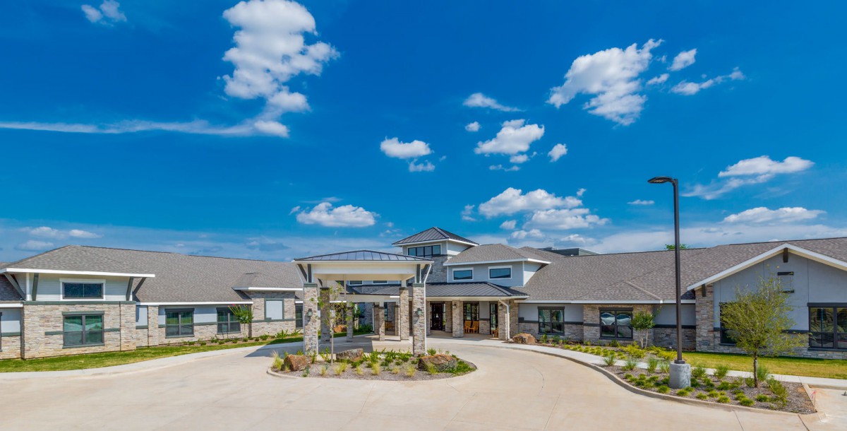 A scenic view of a modern building under a clear blue sky with clouds.
