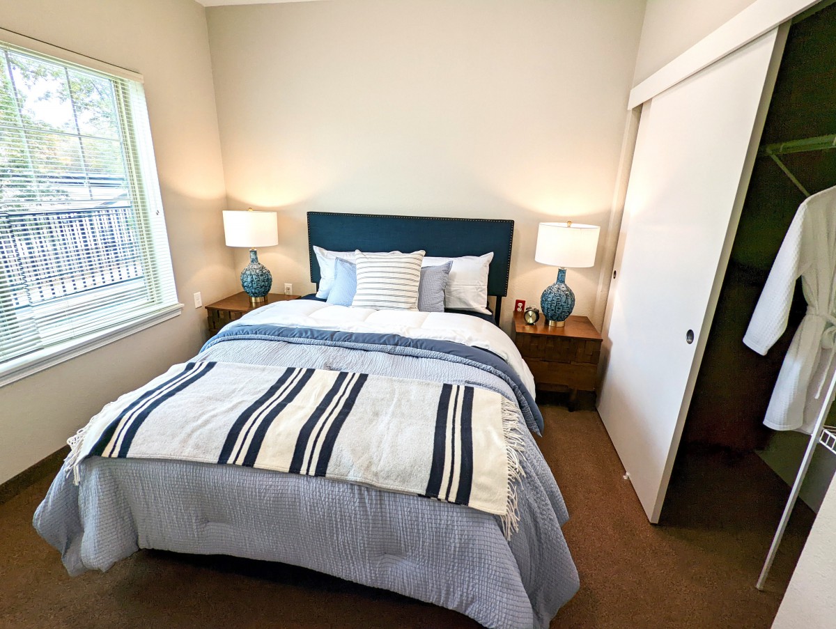 A cozy bedroom with a neatly made bed and two bedside lamps.