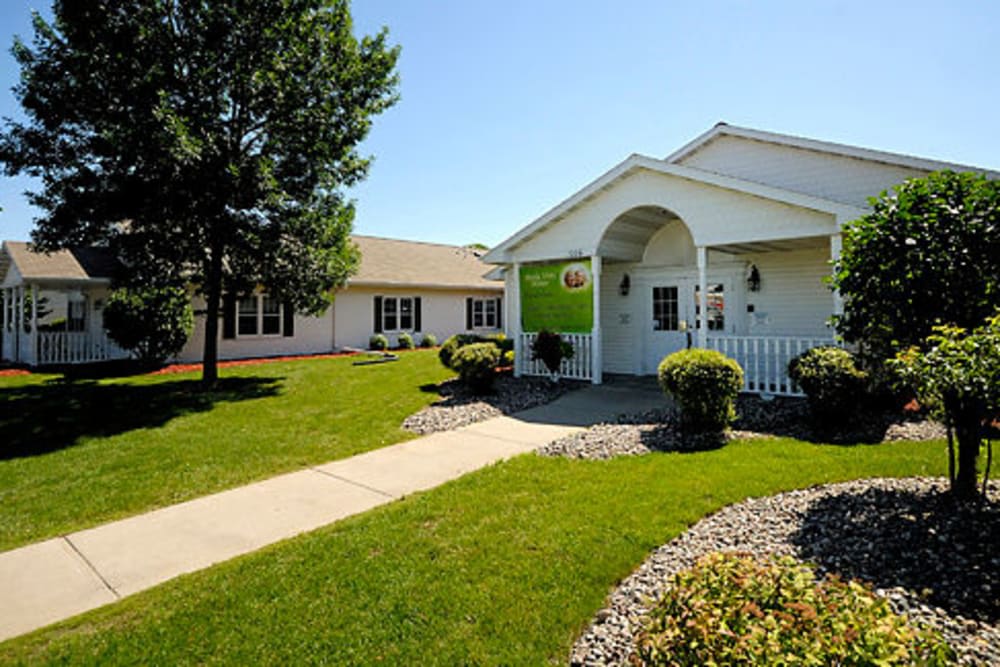 A well-maintained building with a green lawn and pathway leading up to the entrance.
