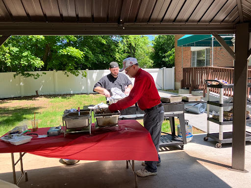 Two friends preparing food on a sunny day in the backyard.