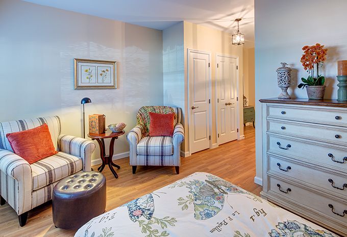 A cozy bedroom with floral patterns and comfortable seating.