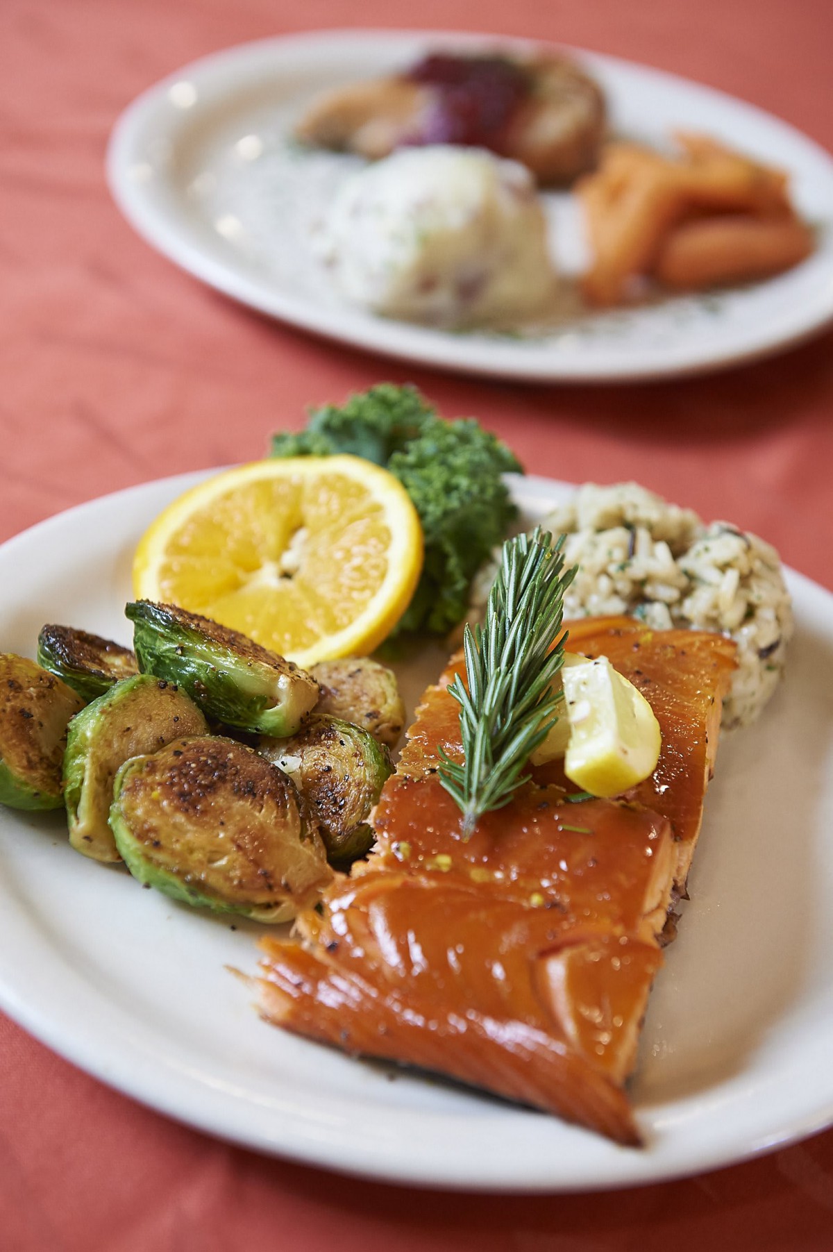 A delicious plate of glazed salmon with Brussels sprouts, rice, and lemon garnish.