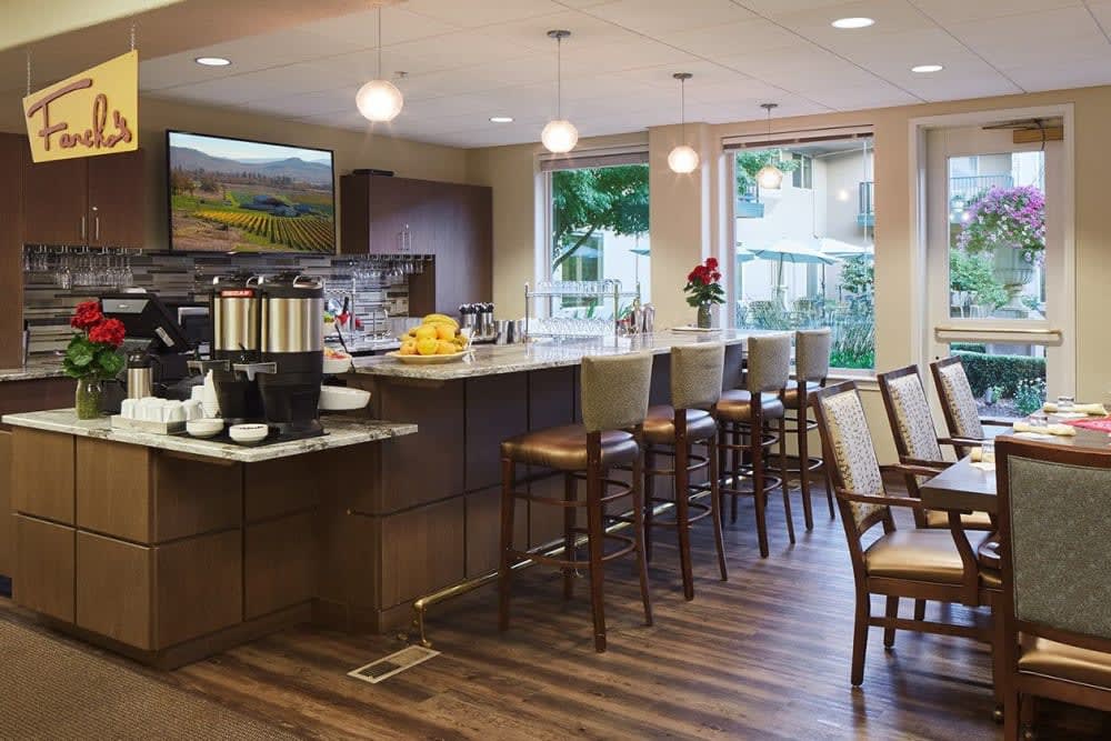 A modern kitchen with a bar area, featuring comfortable seating and stylish lighting.