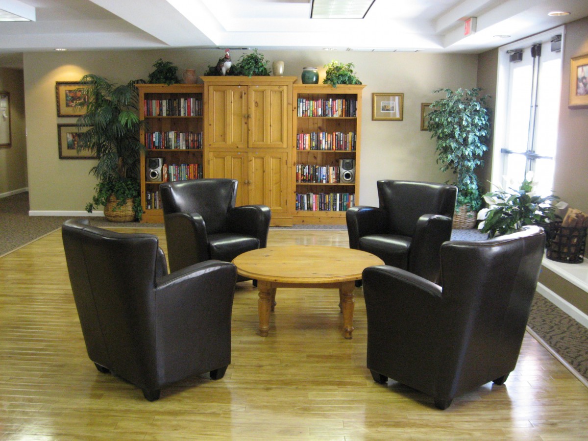 A cozy library corner with leather chairs and wooden bookshelves.