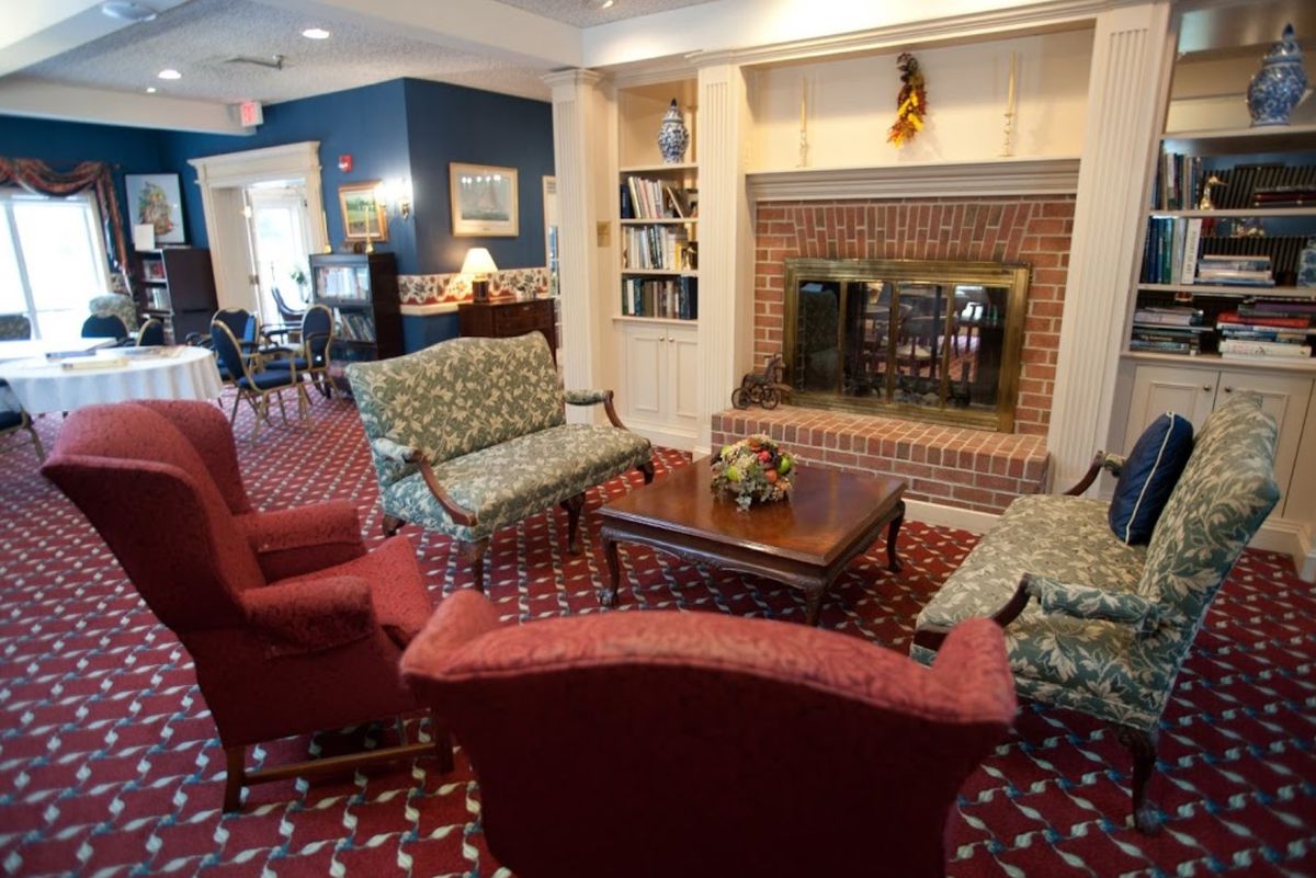 A cozy living room with a brick fireplace, comfortable seating, and a coffee table.