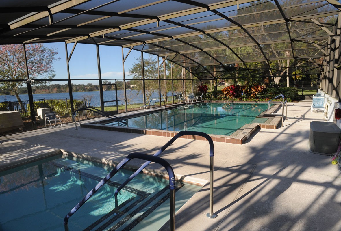 Two indoor pools enclosed by glass, offering a scenic lake view.
