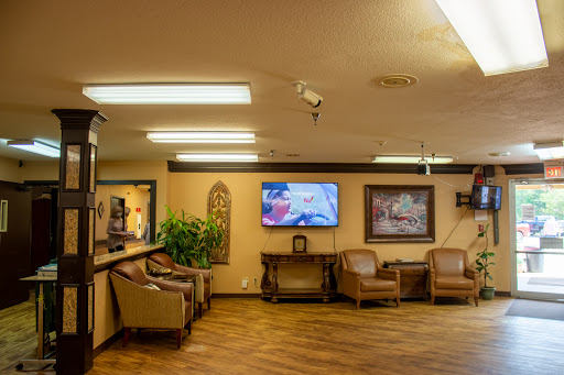 A cozy waiting area featuring comfortable seating, a television, and decorative elements.