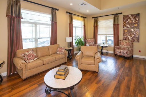 A cozy living room featuring a comfortable sofa, armchairs, and a stylish coffee table, illuminated by natural light.