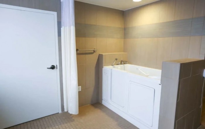 A modern bathroom featuring a walk-in bathtub designed for accessibility.
