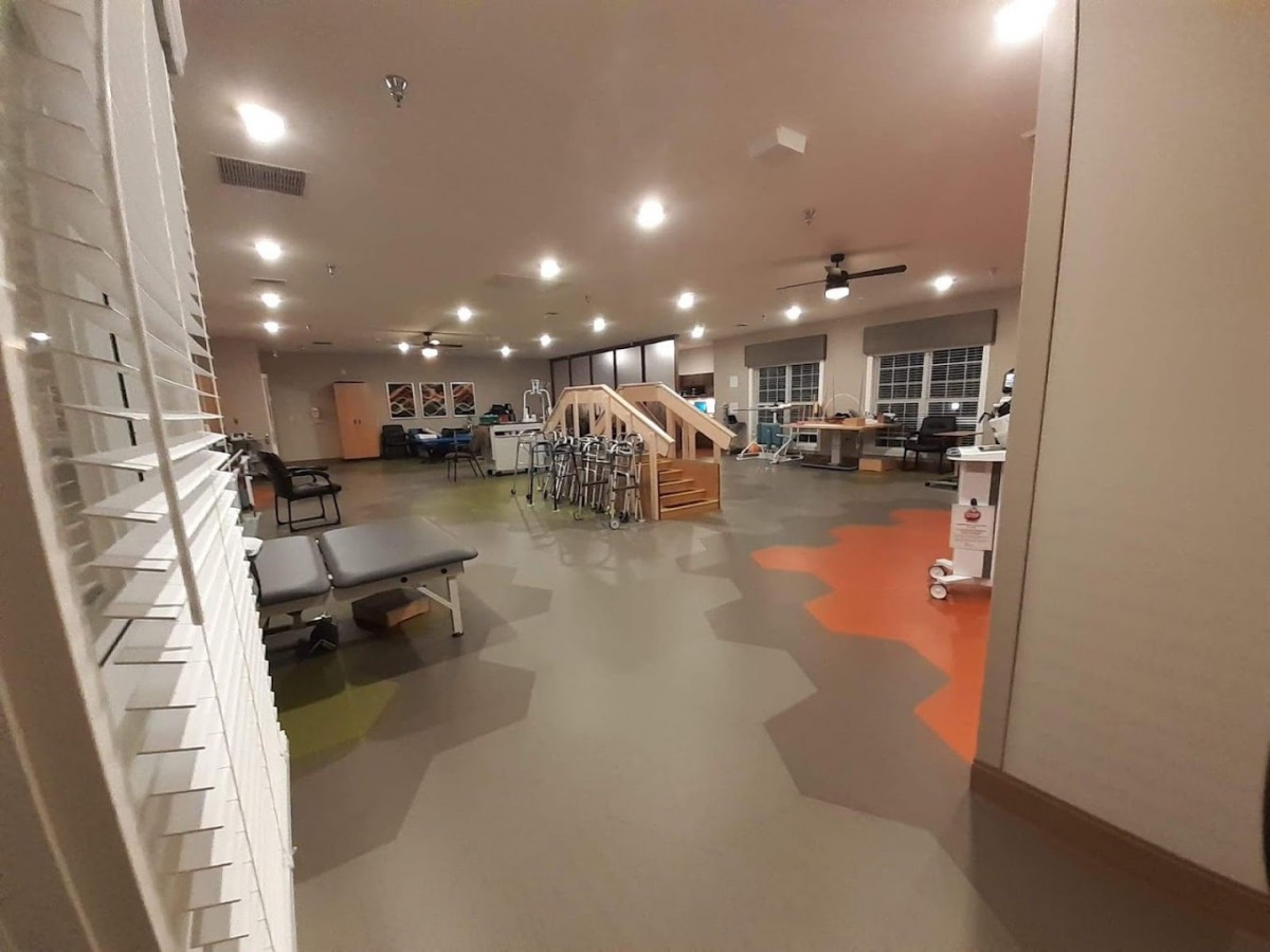 A spacious, well-lit gym featuring exercise equipment and treadmills.