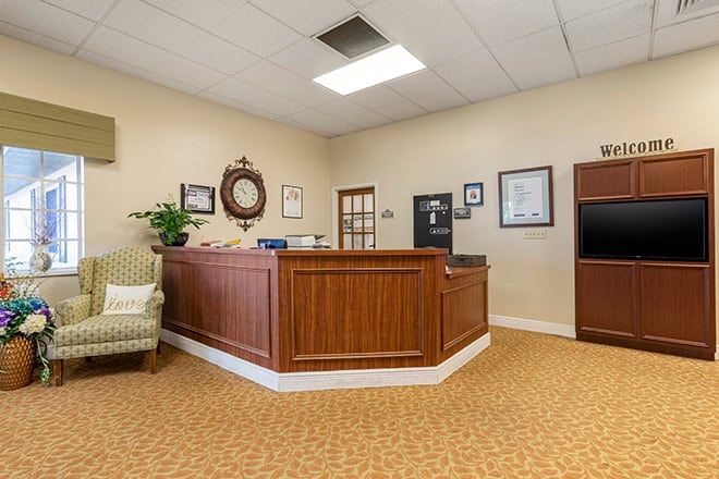 A neat and tidy reception area with a wooden desk and comfortable seating.