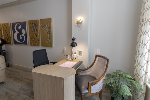 A modern reception area featuring a sleek desk, comfortable seating, and artistic wall decor.