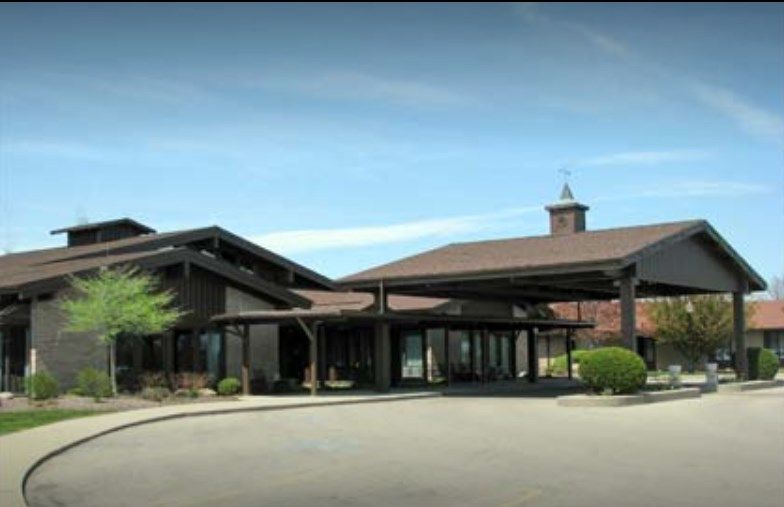 A modern building with a prominent entrance under a clear blue sky.
