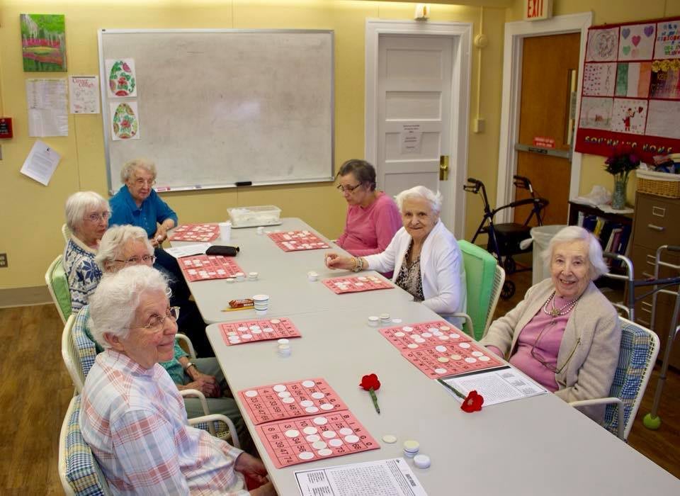 A group of seniors sitting around a table in a community meeting.