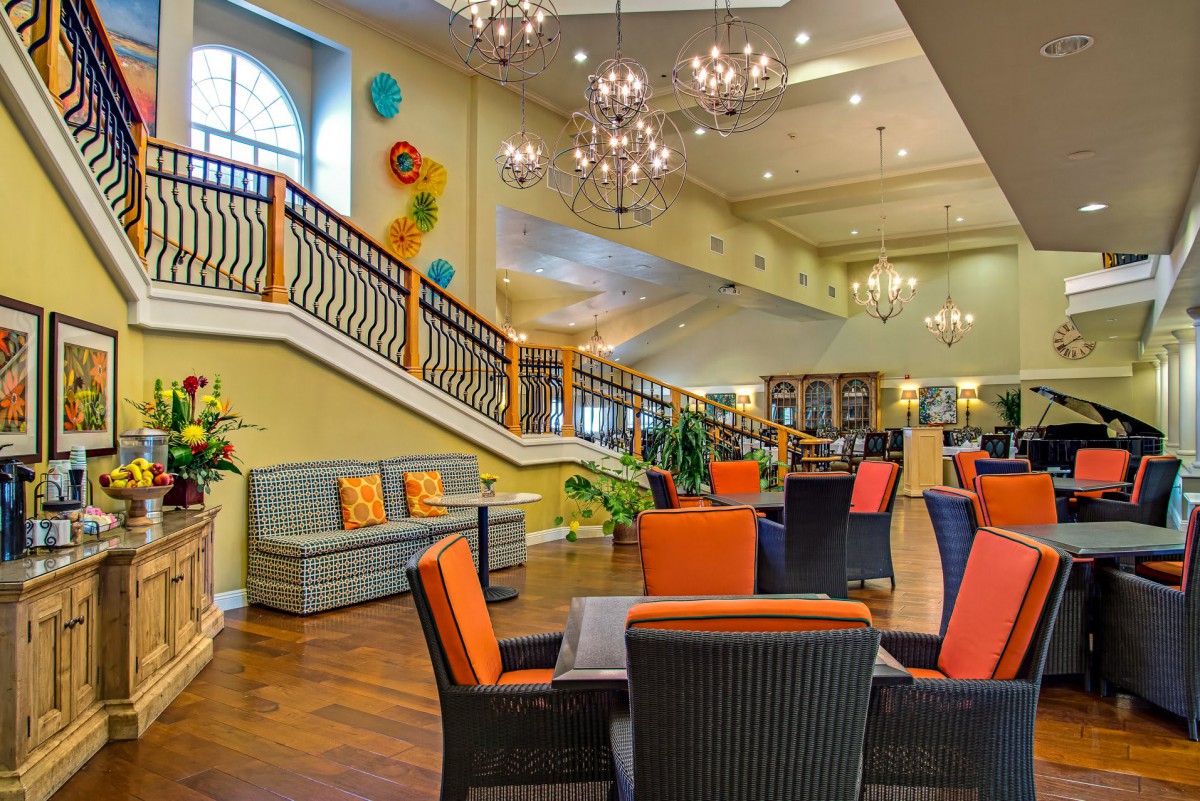A vibrant and modern lounge area with colorful seating and elegant chandeliers.