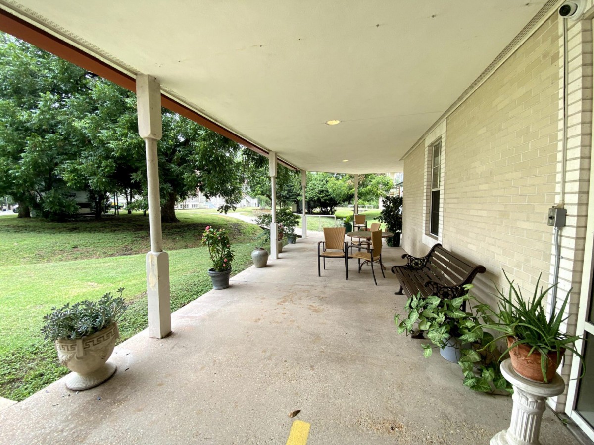 A cozy porch with outdoor furniture and plants, perfect for relaxation.