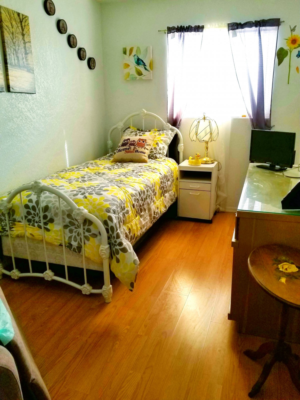 A cozy bedroom with a single bed and a desk by the window.