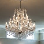 An elegant crystal chandelier hanging from the ceiling, illuminating the room with warm light.