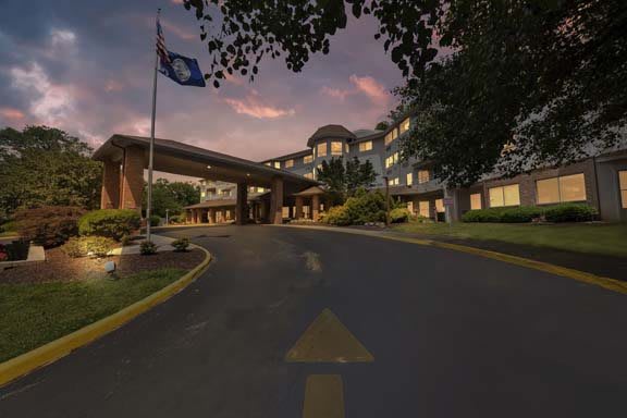 A grand building entrance with a flag at sunset.