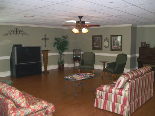 A cozy living room area featuring comfortable chairs and a ceiling fan, perfect for relaxation.