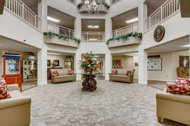 A spacious lobby featuring elegant decor, comfortable seating, and a grand chandelier.