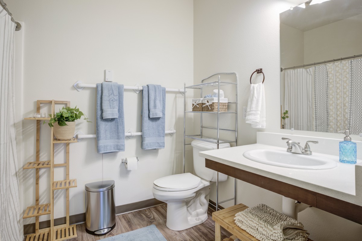 A modern bathroom with neatly organized towels, a toilet, and a sink.