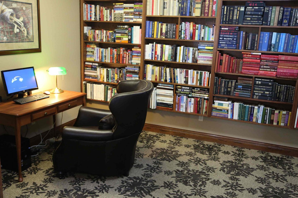 A cozy reading corner with a chair and bookshelves filled with books.