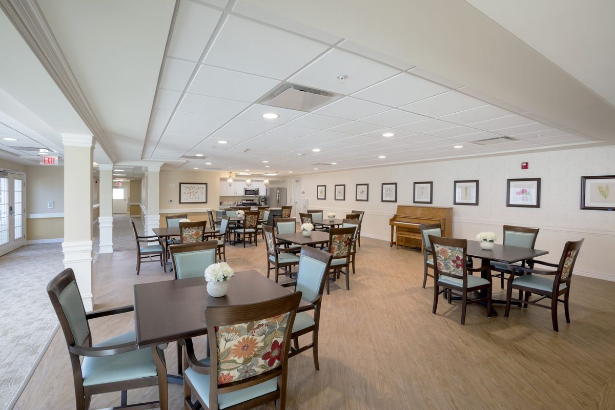An inviting dining area with neatly arranged tables and chairs, adorned with simple decor.