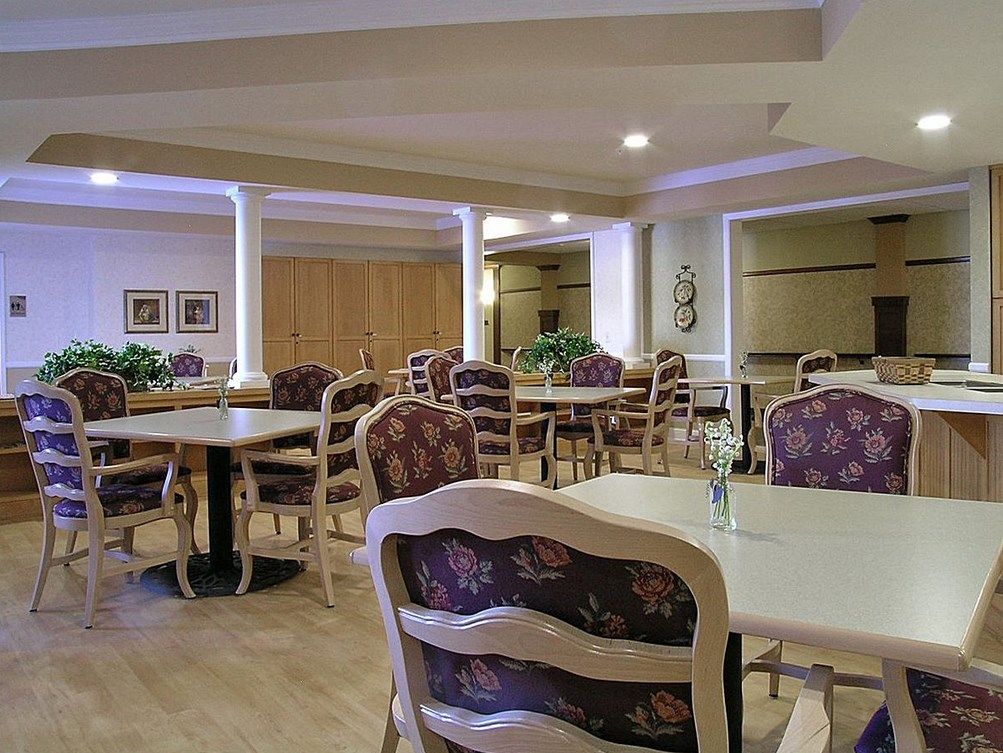An empty dining room with neatly arranged tables and chairs.