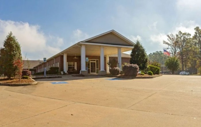 A building with a grand entrance featuring columns and surrounding landscaping.