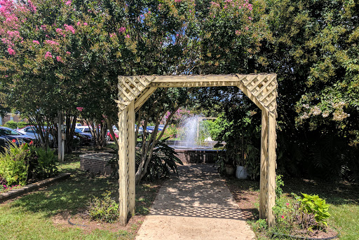 A charming garden archway leading to a serene area surrounded by lush greenery.