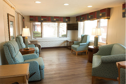 A cozy sitting area with comfortable blue chairs and natural light.