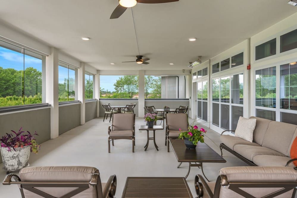 A spacious covered patio with comfortable outdoor seating and ceiling fans.