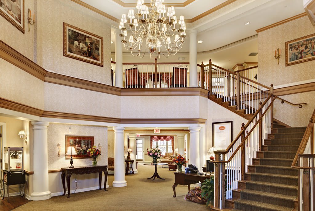 Elegant hotel lobby with a grand chandelier and staircase.