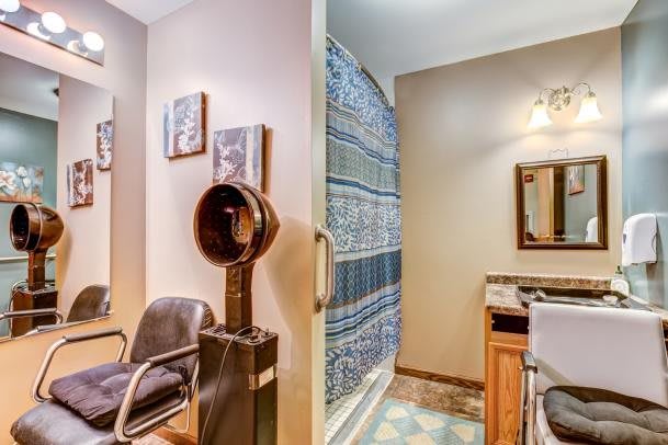 A cozy salon setup with a hair drying station next to a bathroom area.