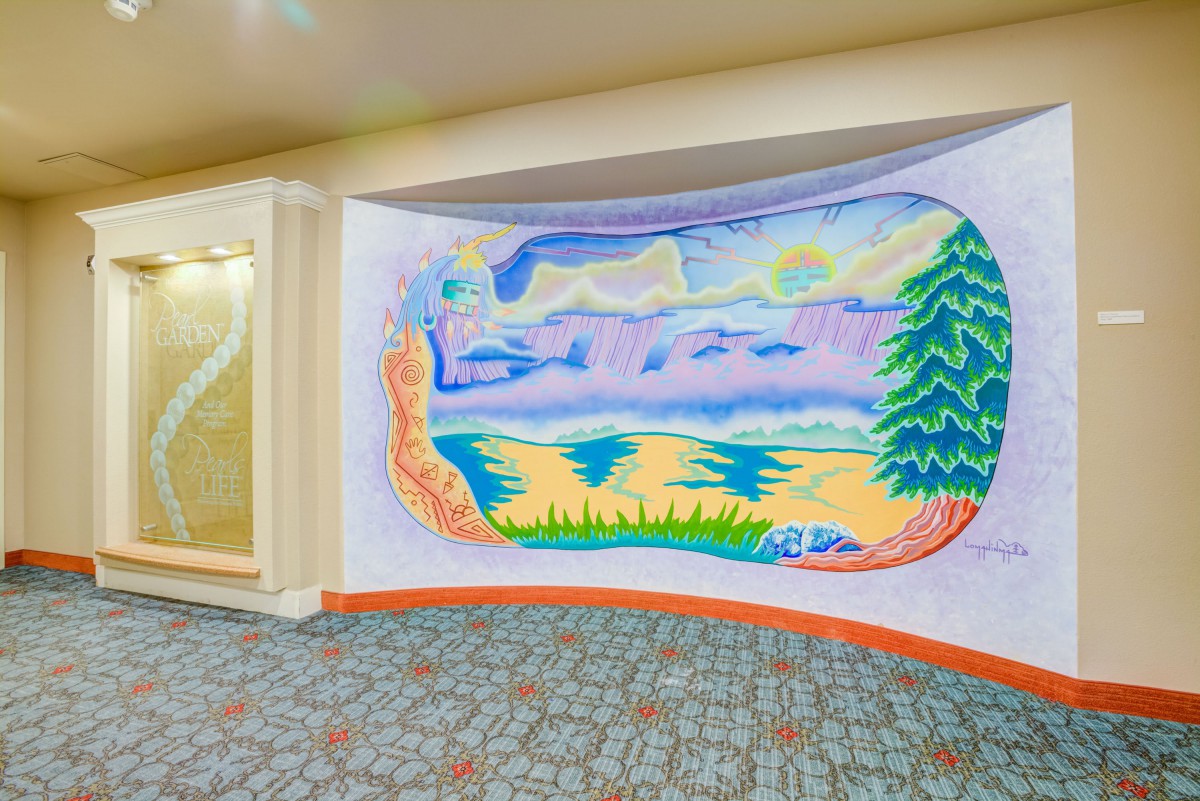 A colorful mural depicting a scenic landscape indoors.