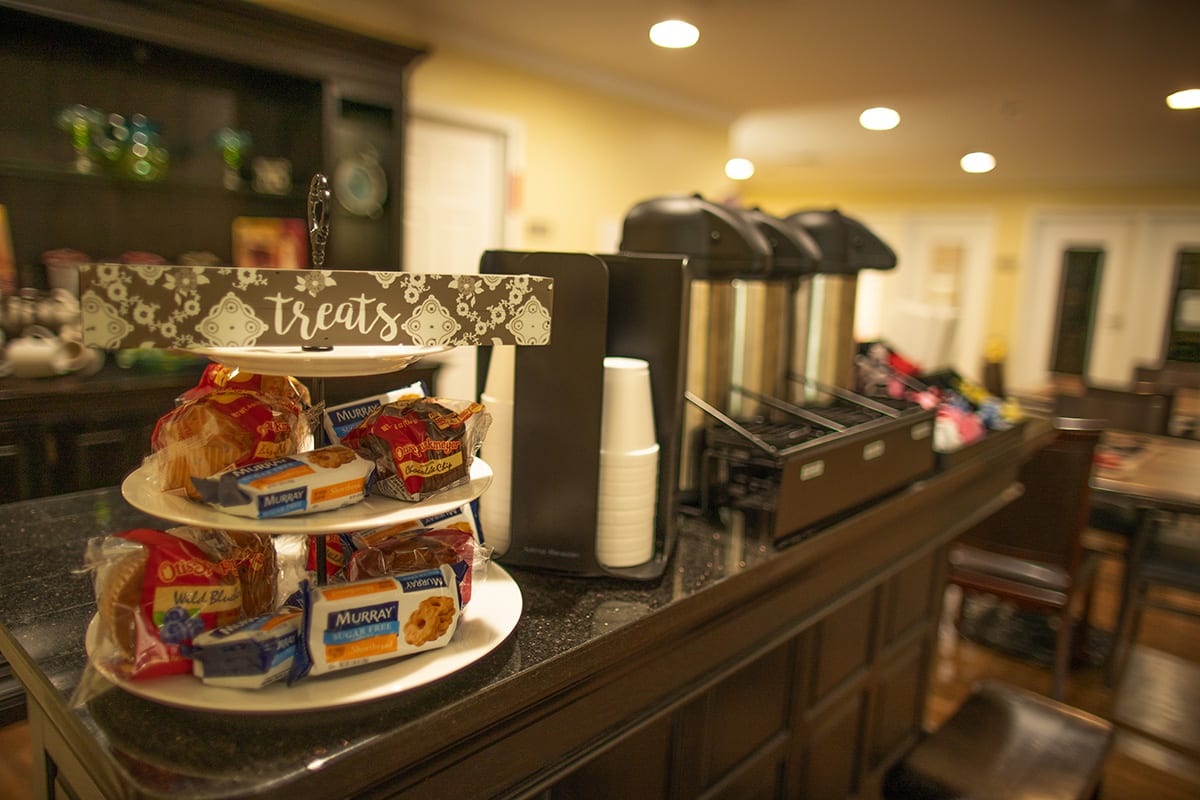 A coffee station in a hotel lobby featuring snacks and refreshments.