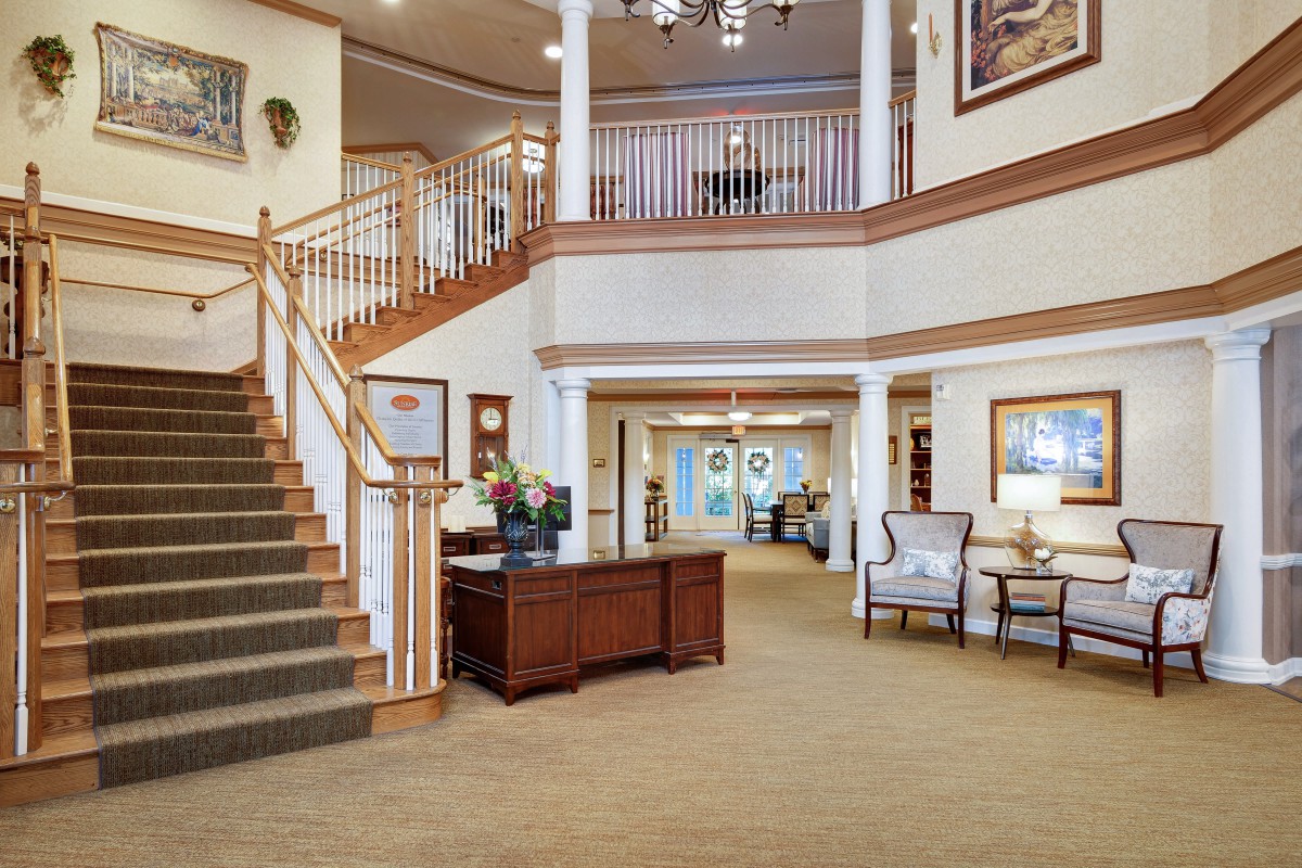 A welcoming lobby with a staircase and reception desk, featuring elegant decor and comfortable seating.
