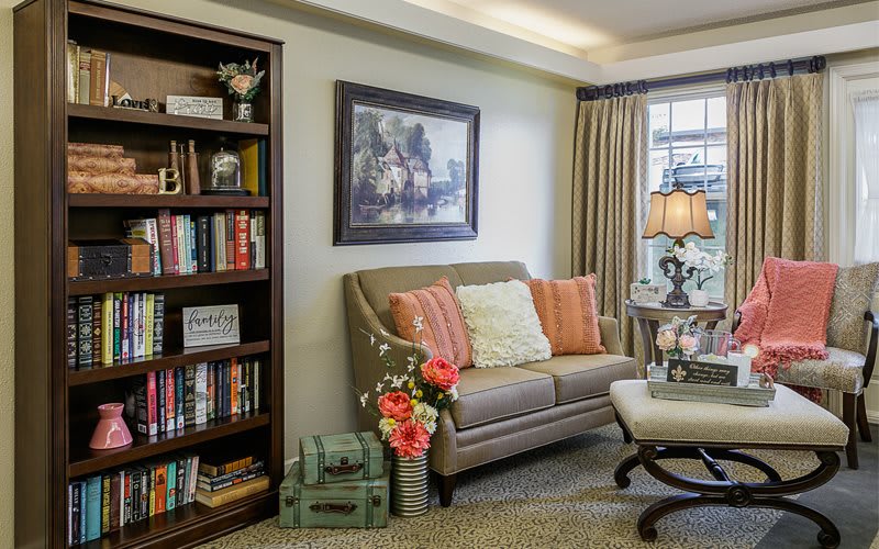 A cozy living room with a comfortable sofa, bookshelf filled with books, and elegant decor.